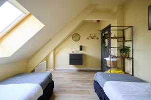 two beds in a attic bedroom with yellow walls at Herberg, Het Wapen van Tilburg in Tilburg