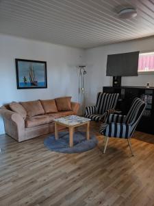 a living room with a couch and a table and chairs at Lägenhet Bolum 7 in Broddetorp