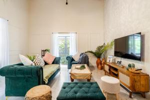 a living room with two couches and a tv at Casa Century Anjuna in Anjuna