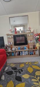 a living room with a television and a rug at 128 Lido Beach in Prestatyn