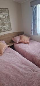 two beds sitting next to each other in a room at 128 Lido Beach in Prestatyn