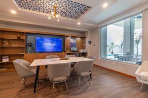 a dining room with a table and chairs and a tv at TRYP by Wyndham Mayaguez in Mayaguez