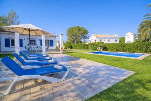 a group of lounge chairs with an umbrella next to a swimming pool at M014 Paraiso by Mallorca Villa Selection in Alcudia