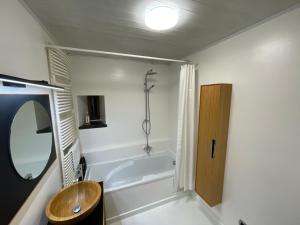 a bathroom with a tub and a sink and a mirror at Grange de la Rochette - 1 à 6p in Jamoigne +23 photos