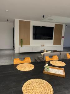 a living room with a table with chairs and a tv at L'Arsenal Loft in Couvin