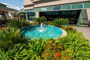 a swimming pool with a fountain in front of a building at Flats Osasco Trade Center in Osasco