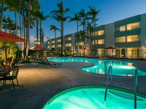 a pool at a resort with palm trees and a building at Ventura Beach Marriott in Ventura
