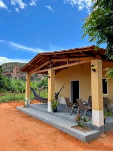 a porch of a house with chairs and a roof at aconchego da serra in Coronel José Diaz