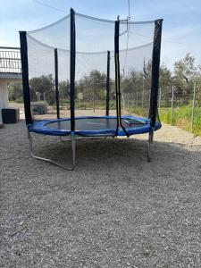 a blue trampoline with a net at K1 studios ενιαίος χώρος in Sidhirodhromikós Stathmós Aitolikoú