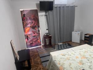 a living room with a bed and a painting on the wall at Pousada Jangarelli in Guaíra +23 photos