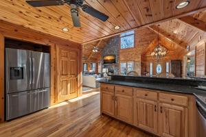 a kitchen with wooden cabinets and a stainless steel refrigerator at Johnny's Lakeside Hideaway in Morganton