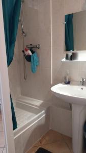 a small bathroom with a shower and a sink at Studio Neptune in Arromanches-les-Bains
