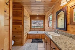 a log cabin bathroom with a tub and a sink at Johnny's Lakeside Hideaway in Morganton +70 photos