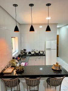 a kitchen with a counter with chairs and a refrigerator at aconchego da serra in Coronel José Diaz +7 photos