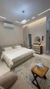 a bedroom with a large bed and a table at top one in Taif +7 photos