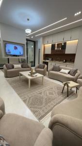 a living room with couches and a flat screen tv at top one in Taif