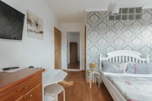a bedroom with a large white bed and a desk at Willa Sarenka in Międzyzdroje