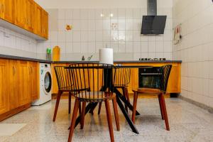 a kitchen with a table and chairs in a kitchen at T3 Duplex - Tsimkoura in Chirongui +9 photos