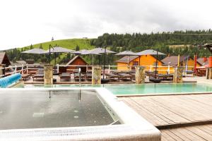 a swimming pool with tables and chairs in a resort at Гук готельно-ресторанний комплекс in Bukovel