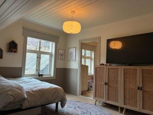 a bedroom with a bed and a flat screen tv at Lake House in Vossevangen