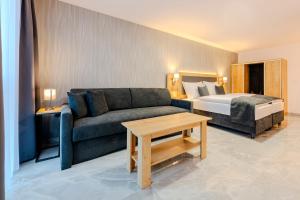 a living room with a couch and a bed at Hotel Tříška in Brandýs nad Labem