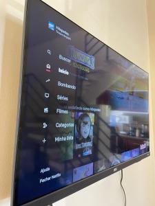 a television screen with a picture of a woman at Casa Aconchego do Mar in Japaratinga