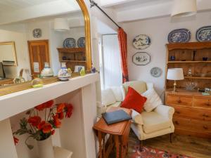 a living room with a chair and a mirror at St Dominic Cottage in St Ives