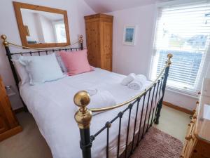 a bedroom with a bed and a window at St Dominic Cottage in St Ives