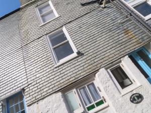 a house with a clock on the front of it at St Dominic Cottage in St Ives