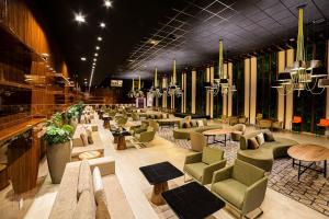 a large lobby with chairs and tables and chandeliers at Taua Hotel e Convention Alexania in Alexânia