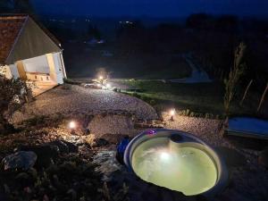 a bath tub in a yard at night at Bagolyvölgy Tulkó Ház in Balatonhenye
