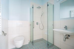 a bathroom with a shower and a toilet and a sink at Ava Apartamenty in Niechorze +53 photos