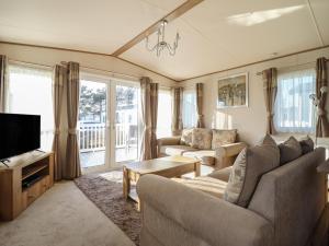 a living room with two couches and a tv at 23 Gull Court in Porthmadog