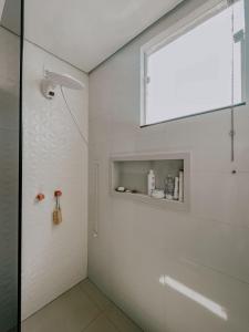 a bathroom with a shower with a glass door at Suítes em casa ampla com área gourmet in Uberlândia +35 photos