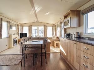 a kitchen and living room with a table and chairs at 23 Gull Court in Porthmadog