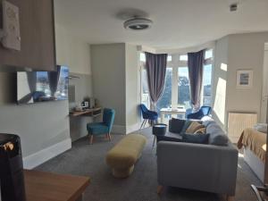 a living room with a couch and chairs and a table at Harmony Apartments in Weston-super-Mare