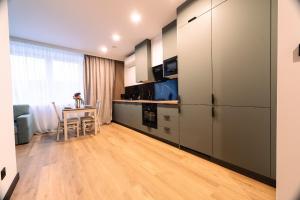 a kitchen with stainless steel appliances and a table at ApartHouse in Klimontów