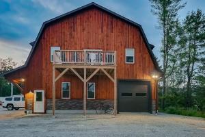a large red barn with a balcony and a garage at Valley Vista Vacay in Littleton