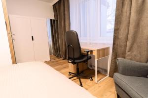 a bedroom with a desk and a chair and a bed at ApartHouse in Klimontów