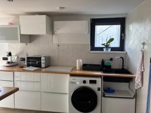 a kitchen with a washing machine and a window at Trinity in Balatonalmádi +3 photos
