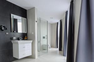 a bathroom with a sink and a toilet and a mirror at Hotel Tříška in Brandýs nad Labem