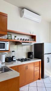 a kitchen with wooden cabinets and a white refrigerator at Star Department We bill in La Paz +8 photos
