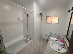 a bathroom with a tub and a sink and a toilet at Sevilla Gateway a 10 min Sevilla y cerca aeropuerto, 3 habitaciones, 2 camas en cada habitación y sofá cama in Alcalá de Guadaira +17 photos