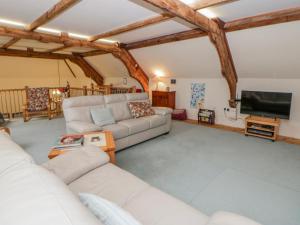 a living room with couches and a flat screen tv at Yr Hen Ysgoldy in Machynlleth