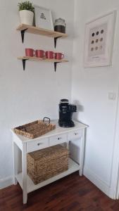 a small white table with baskets on a wall at Apartamento Gaztelugatxe in Bakio