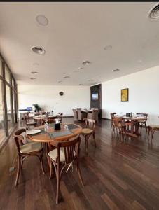 a restaurant with tables and chairs in a room at Samarah E 01 full Sea View and adult pool prime location with garden , in Al Baḩḩāth