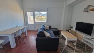 a living room with a couch and a table and a television at Apartamento Gaztelugatxe in Bakio