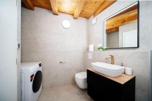 a bathroom with a sink and a washing machine at Stone House Dida Toni Tribunj in Tribunj +45 photos