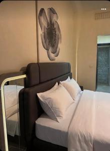 a bedroom with a bed with a flower on the wall at Samarah E 01 full Sea View and adult pool prime location with garden , in Al Baḩḩāth +48 photos