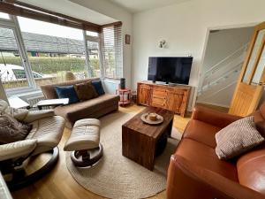 a living room with couches and a flat screen tv at Central Taunton Townhouse in Taunton